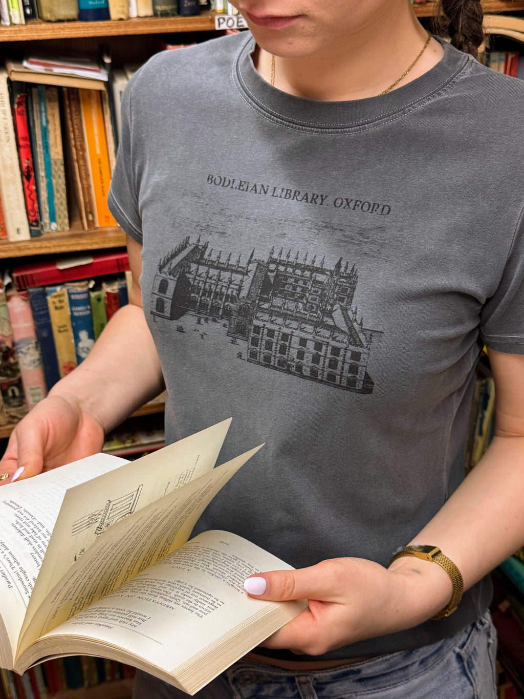 woman reading a book and wearing a hanabi club tshirt