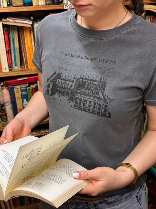 woman reading a book and wearing a hanabi club tshirt