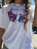 Close-up of the “Book Club Lounge” T-shirt graphic on a white tee.