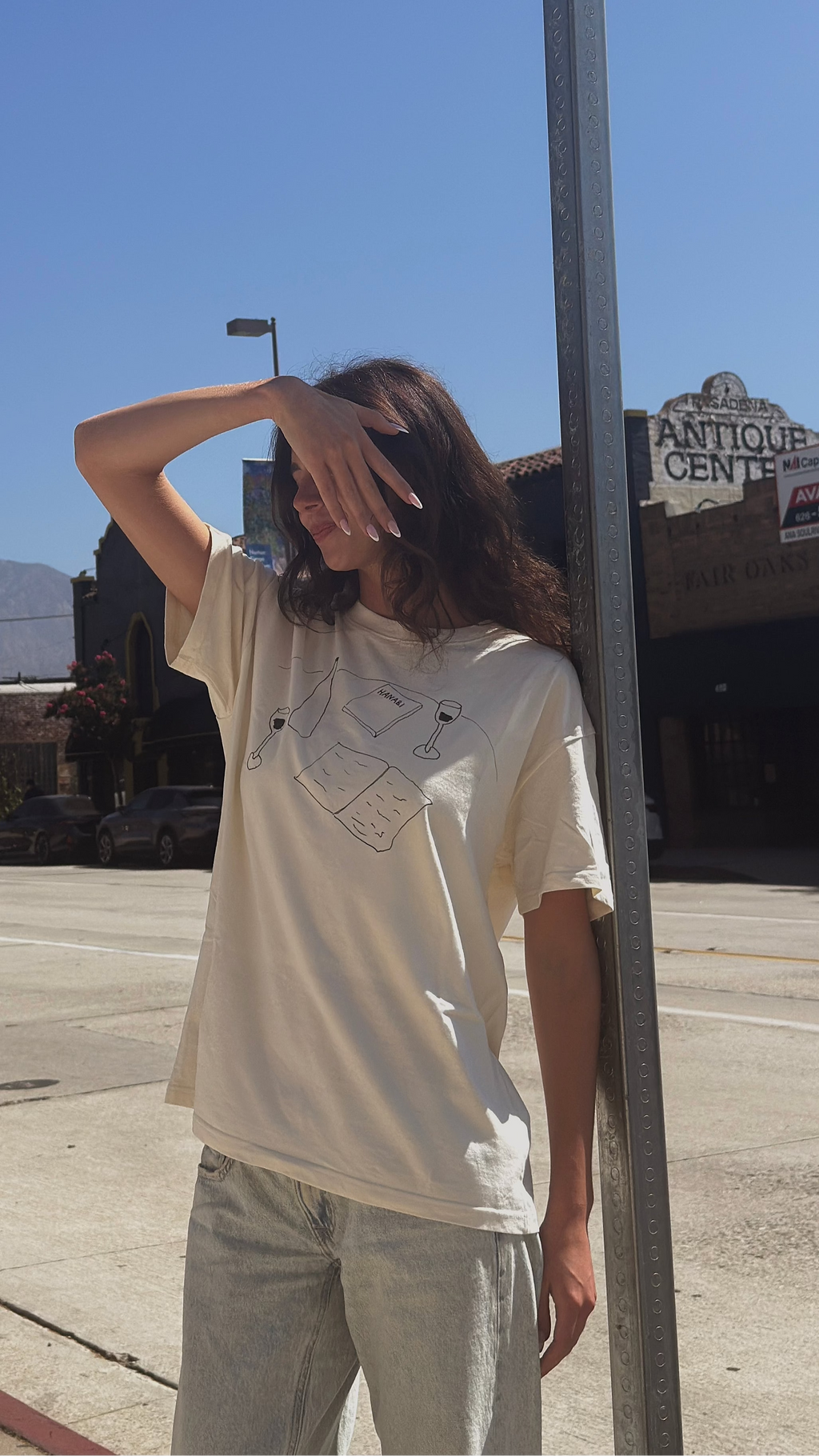 Model wearing the “Books and Wine” T-shirt outdoors in the sun.