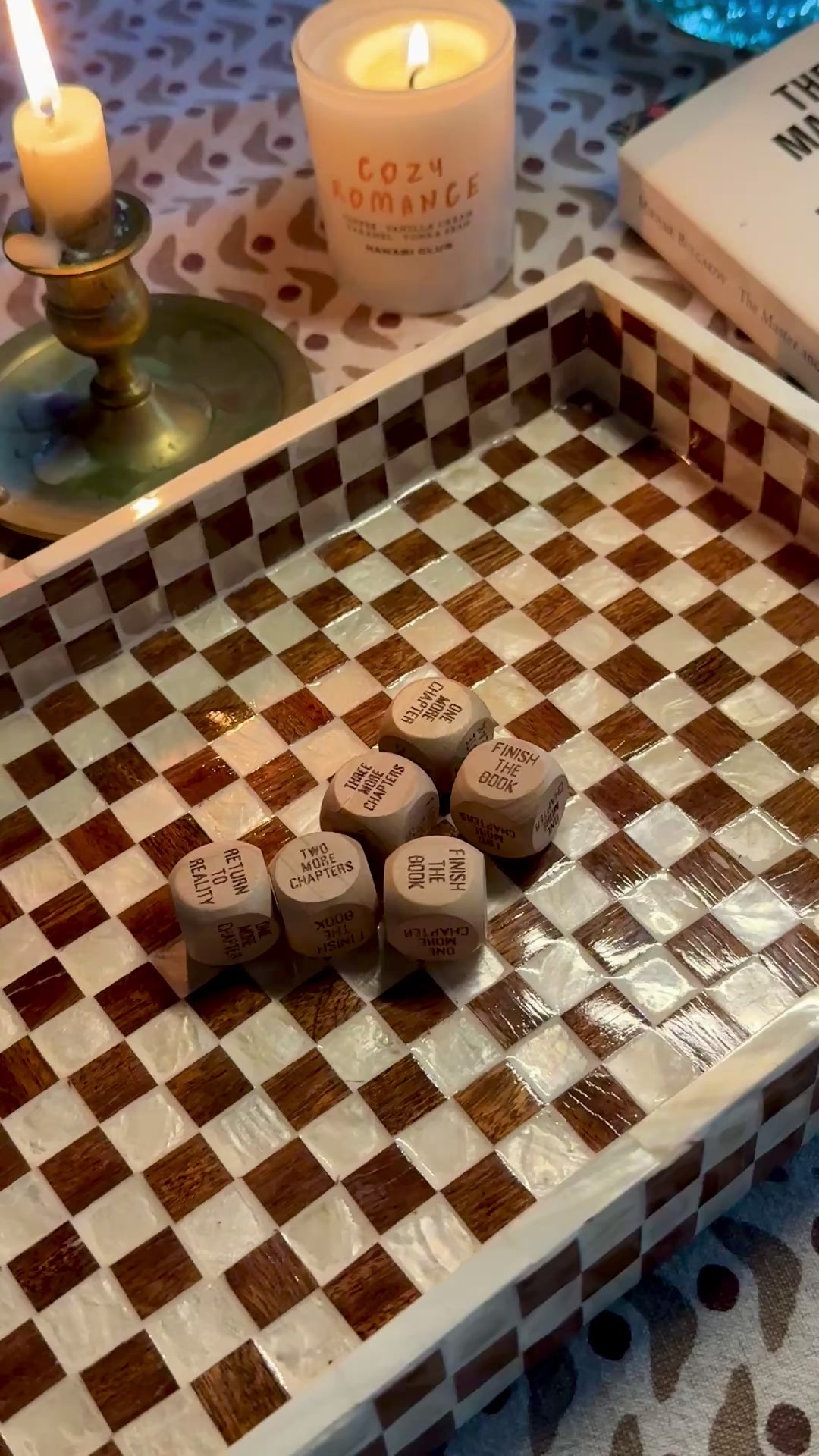 Video showing HANABI CLUB wooden Reading Decision Dice on a chequered tray beside books and candles.