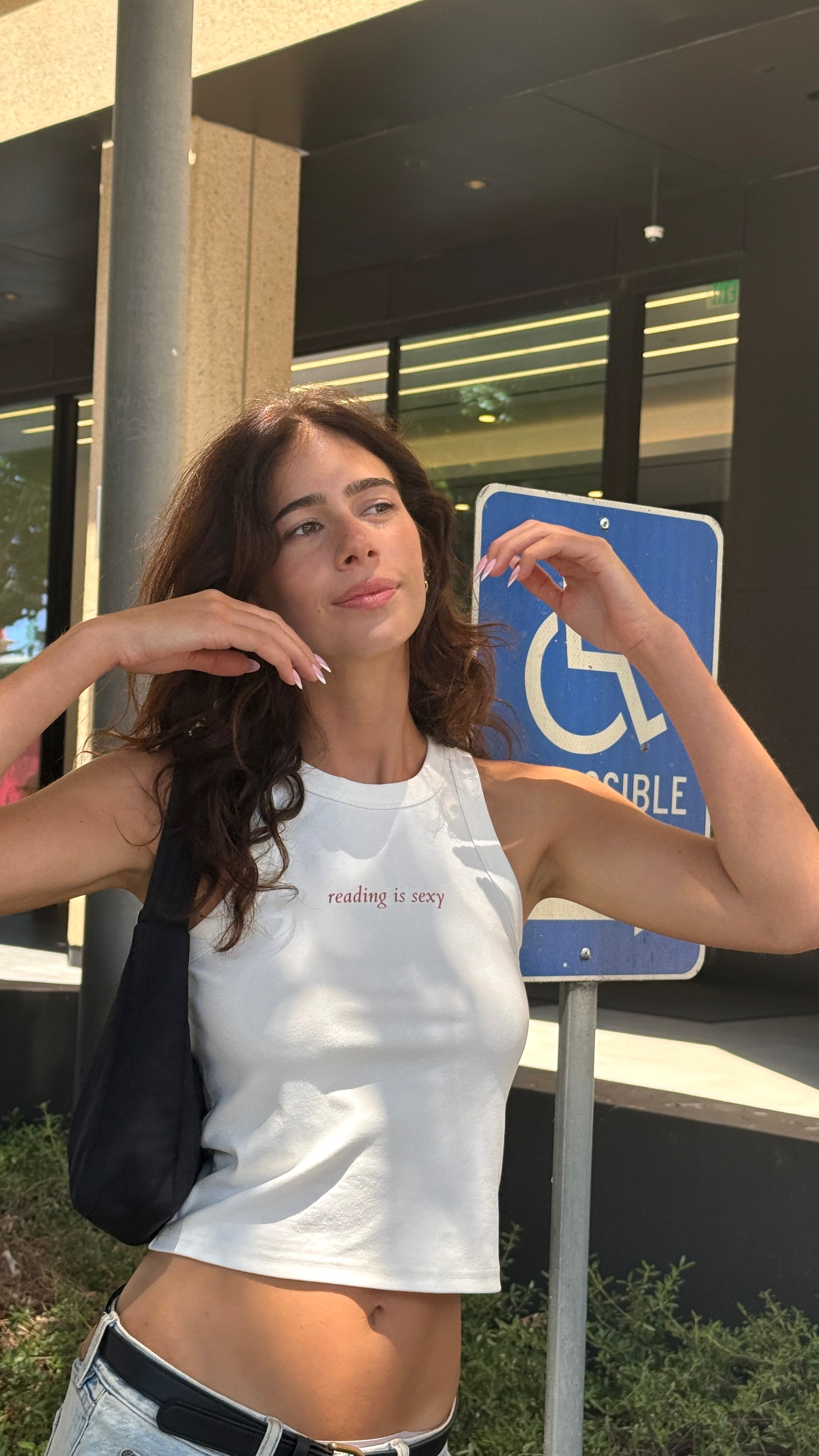 Model wearing a white “reading is sexy” tank top and jeans in Pasadena.